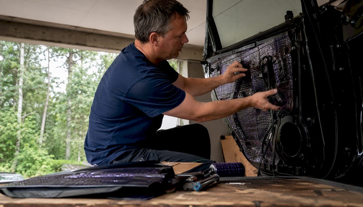 Ein Mann isoliert die Autotür in seiner Garage.